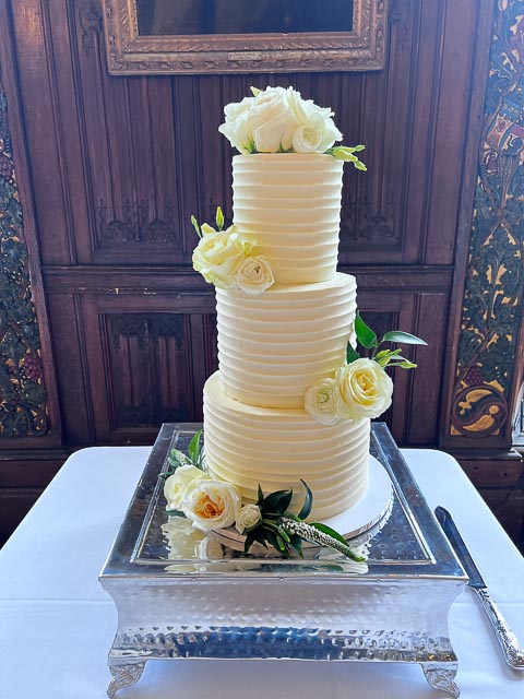 Three tier buttercream wedding cake with fresh white roses at Rothamsted Manor